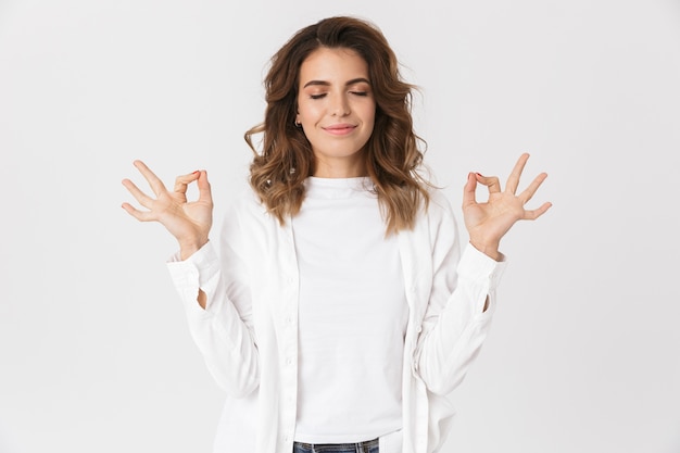 Photo portrait de femme caucasienne positive dans des vêtements décontractés faisant des gestes, tout en isolé sur blanc