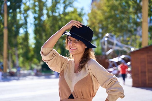 portrait d'une femme avec un chapeau regardant la caméra