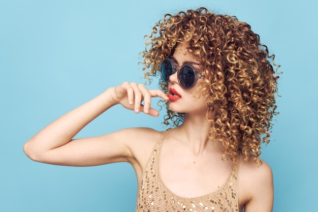 Portrait d'une femme cheveux bouclés lèvres rouges charme fond bleu rouge à lèvres