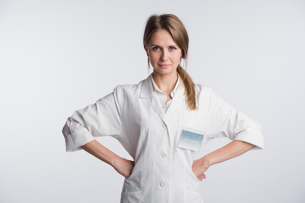 Portrait de femme chirurgien médecin dans une pose confiante isolé avec les mains sur les hanches