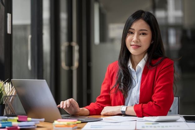 Portrait de femme comptable au bureau utilisant un ordinateur portable et une calculatrice pour la comptabilité