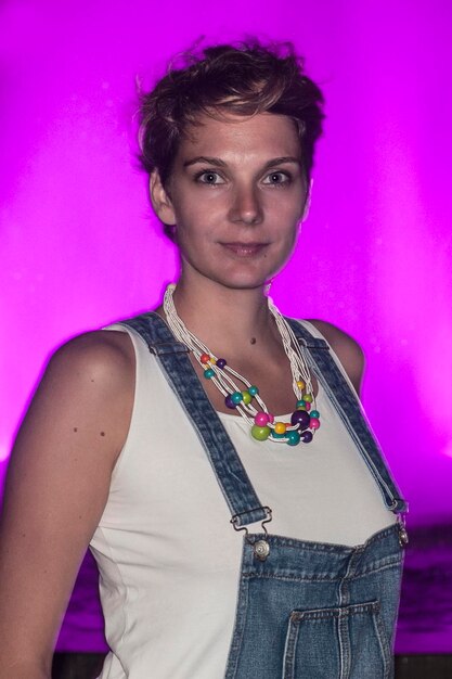 Photo portrait d'une femme contre une cascade rose la nuit