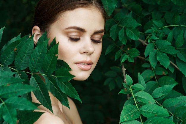 Portrait d'une femme cosmétologie nature feuilles vertes modèle glamour