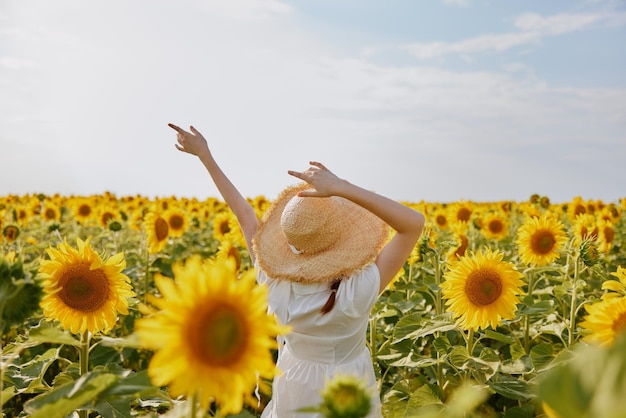 Portrait de femme dans un champ avec l'heure d'été de tournesols en fleurs