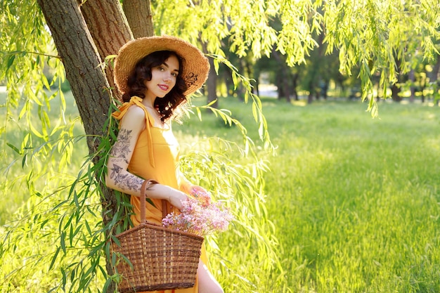 Portrait d'une femme dans un chapeau de paille en été lors d'une promenade