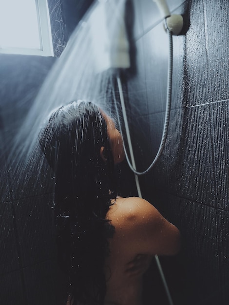 Portrait d'une femme dans la salle de bain à la maison