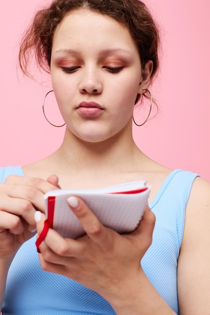 Portrait d'une femme dans un t-shirt bleu avec un bloc-notes rouge et un stylo d'émotions gros plan inchangé