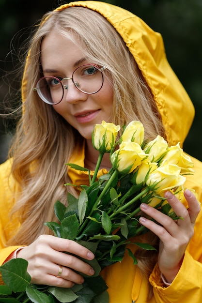 Portrait d'une femme dans des verres avec des fleurs jaunes en gros plan d'automne