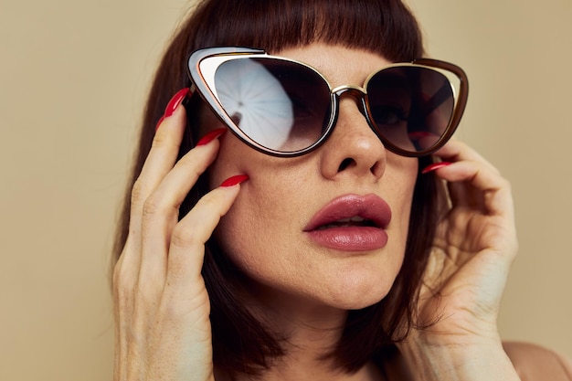 Portrait d'une femme dans une veste beige lunettes de soleil de style élégant fond isolé