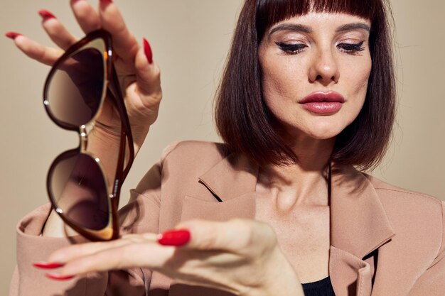 Portrait d'une femme dans une veste beige lunettes de style élégant style de vie inchangé