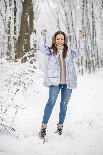 Portrait d'une femme debout dans la forêt d'hiver et posant pour une photo