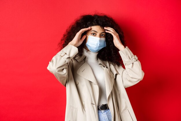 Photo portrait d'une femme debout sur un fond rouge