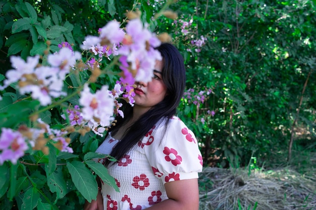 Portrait d'une femme debout près de plantes en fleurs