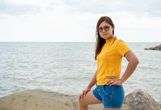 Portrait d'une femme debout sur un rocher avec un fond de mer