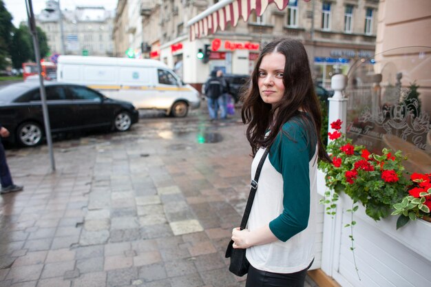 Photo portrait d'une femme debout sur le trottoir de la rue en ville