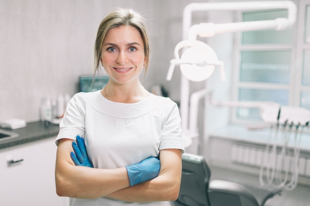 Portrait de femme dentiste. Elle debout dans son bureau de dentiste.