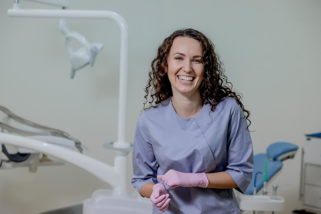 Portrait de femme dentiste .Elle debout dans son cabinet de dentiste.