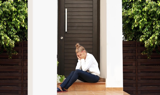 Portrait d'une femme déprimée assise sur les escaliers de la maison Une femme pleurante