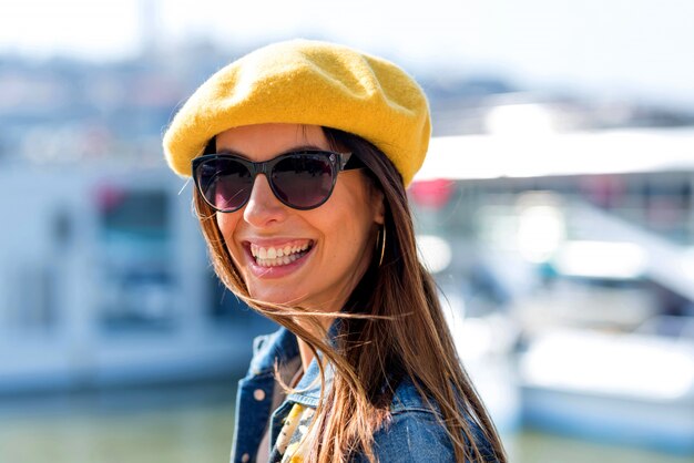 Portrait d'une femme devant un bateau.