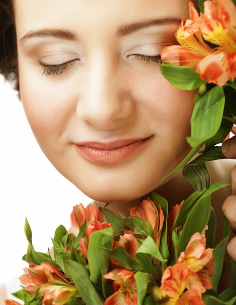 Portrait de femme douce et belle avec des fleurs isolé sur blanc