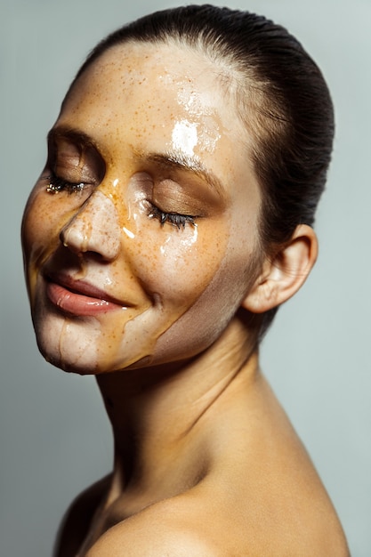 Portrait de femme avec du miel sur son visage