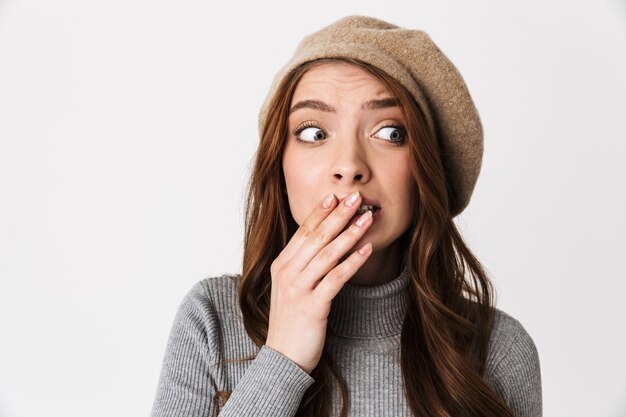 Portrait d'une femme effrayée des années 30 portant un chapeau terrifiant et la bouche coning isolated on white