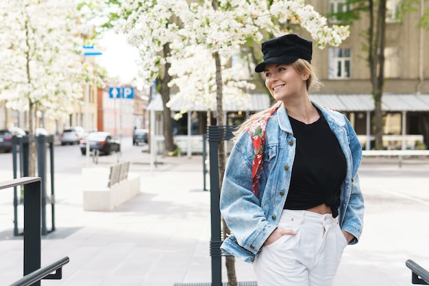 Portrait d'une femme élégante portant une veste en jean et une casquette noire