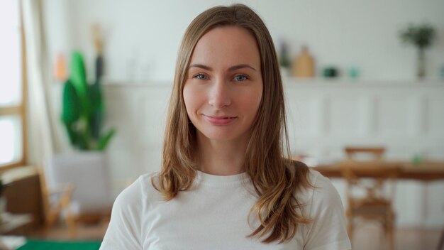 Portrait d'une femme émotionnelle positive qui sourit en regardant la caméra