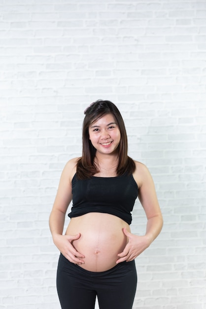 Portrait de femme enceinte d&#39;Asie sur fond blanc