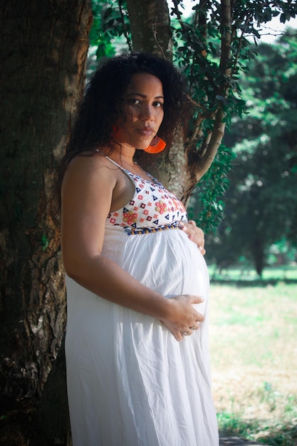 Portrait d'une femme enceinte aux cheveux afro dans la ville