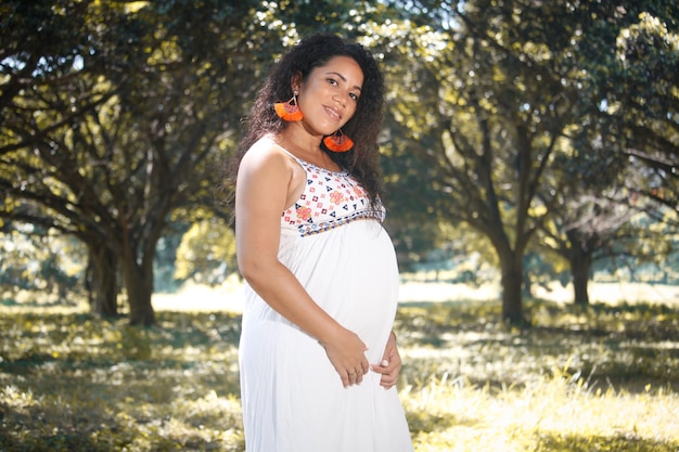 Portrait d'une femme enceinte aux cheveux afro dans la ville