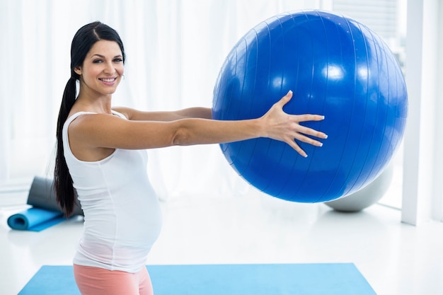 Portrait de femme enceinte avec ballon d'exercice à la maison