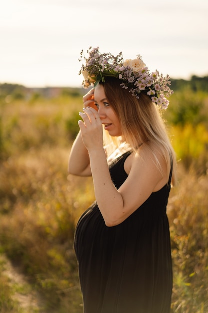 Portrait d'une femme enceinte une belle jeune femme enceinte dans une robe blanche marche dans le domaine