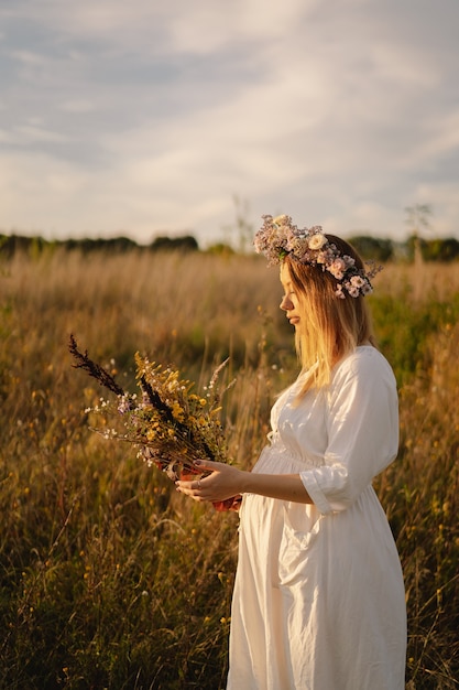 Portrait d'une femme enceinte une belle jeune femme enceinte dans une robe blanche marche dans le domaine