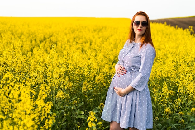 Portrait de femme enceinte sur le champ jaune