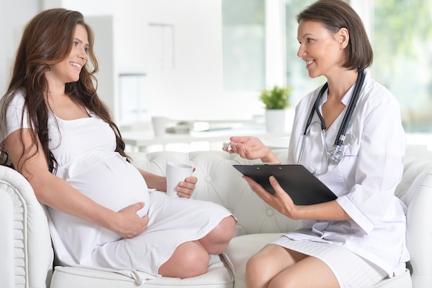 Portrait de femme enceinte heureuse et femme médecin