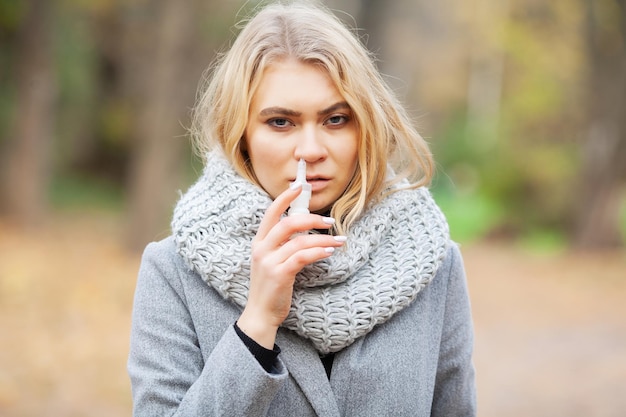 Portrait de femme éternuant en plein air à cause du rhume et de la grippe