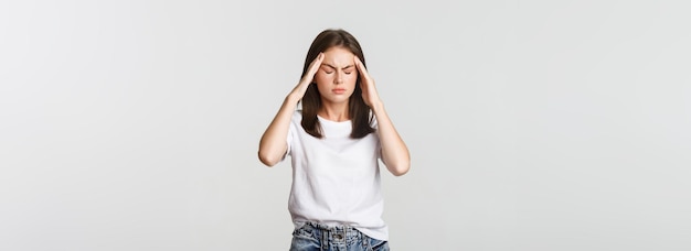 Portrait d'une femme étourdie ou malade touchant la tête et grimaçant de douleur ayant des maux de tête souffrant de migr
