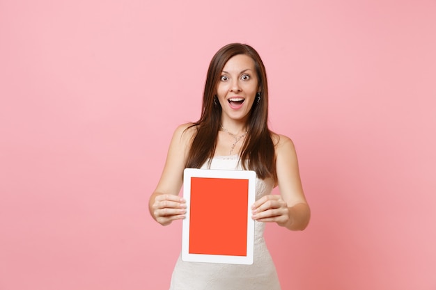 Portrait d'une femme excitée en robe blanche tenir une tablette numérique avec un écran vide noir vierge