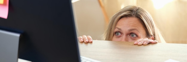 Portrait d'une femme excitée surprise lorgnant sur la table et regardant un employé de bureau à écran pc