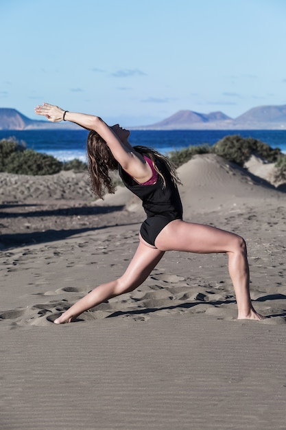 Portrait d'une femme faisant du yoga sur la plage