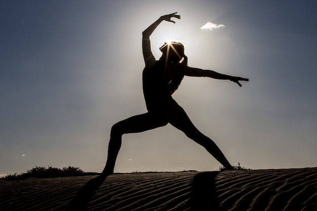 Portrait d'une femme faisant du yoga sur la plage