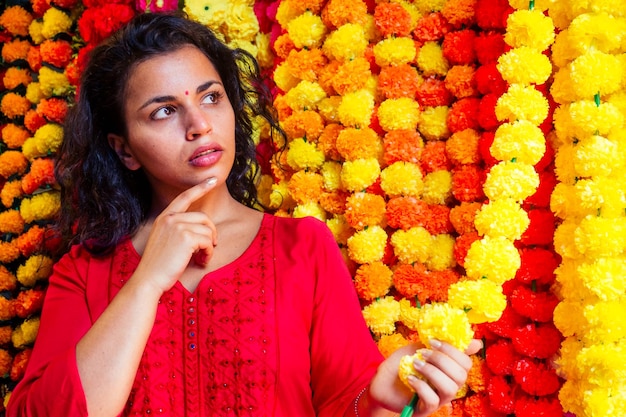 Portrait de femme fleuriste indienne brune dans un bazar floral regardant la caméra et souriant