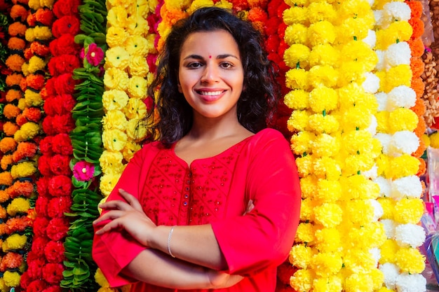 Portrait de femme fleuriste indienne brune dans un bazar floral regardant la caméra et souriant