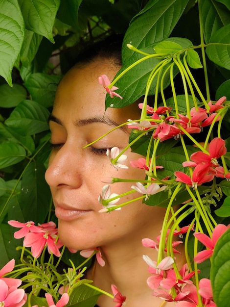 Portrait d'une femme avec des fleurs avec les yeux fermés une avec la nature