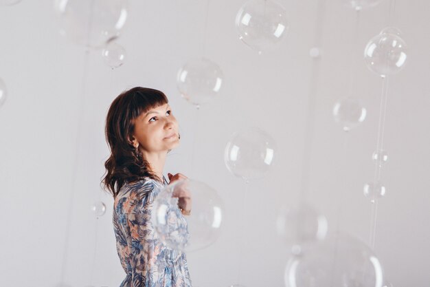 Portrait de femme sur fond blanc avec des boules de verre