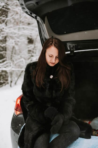 Portrait d'une femme sur le fond d'une forêt enneigée