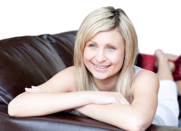 Portrait d&#39;une femme heureuse allongée sur le canapé