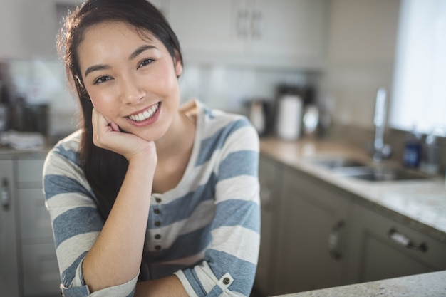 Portrait de femme heureuse assis dans la cuisine