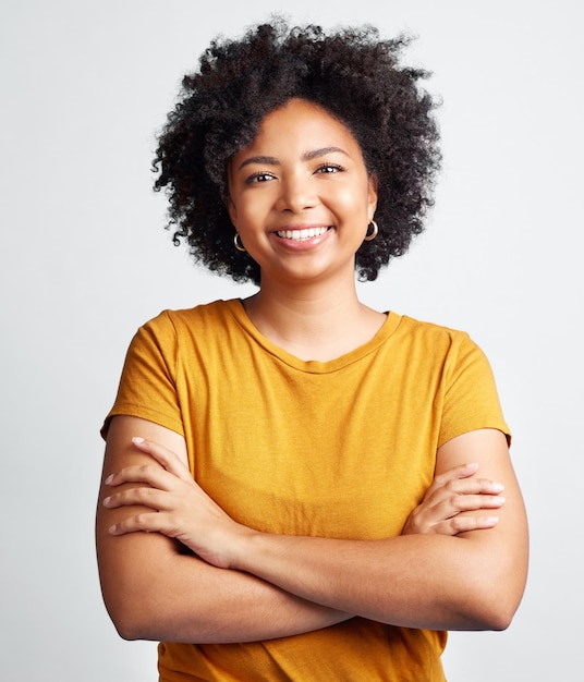 Portrait de femme heureuse bras croisés et confiant en studio fond blanc et toile de fond Jeune modèle féminin africain sourire avec des cheveux bouclés naturels visage positif et gen z fille d'Afrique du Sud